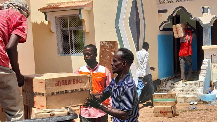 People carry boxes of aid during the flooding caused by heavy rains, in Luuq, Jubaland