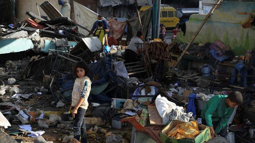 Palestinians inspect the damage at a school sheltering displaced people, in Gaza City