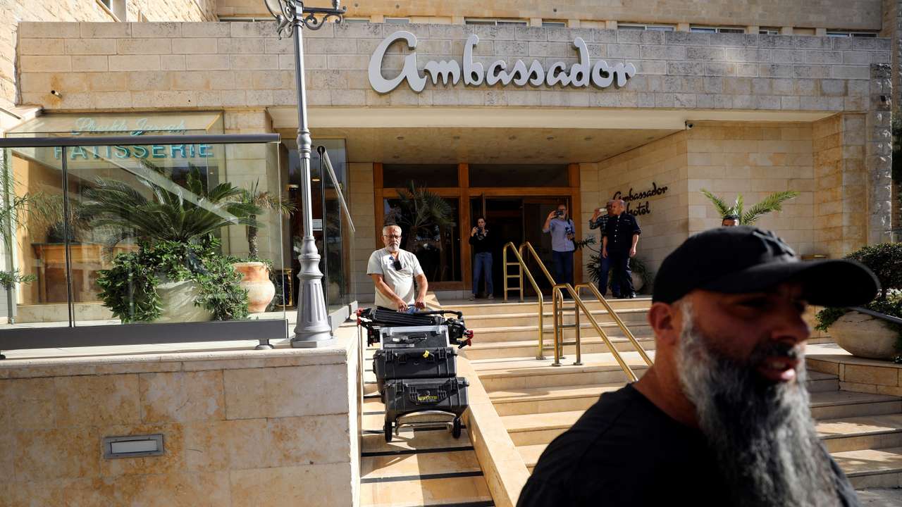 A man maneuvers media equipment following an Israeli police raid on an Al Jazeera de facto office at the Ambassador Hotel in Jerusalem
