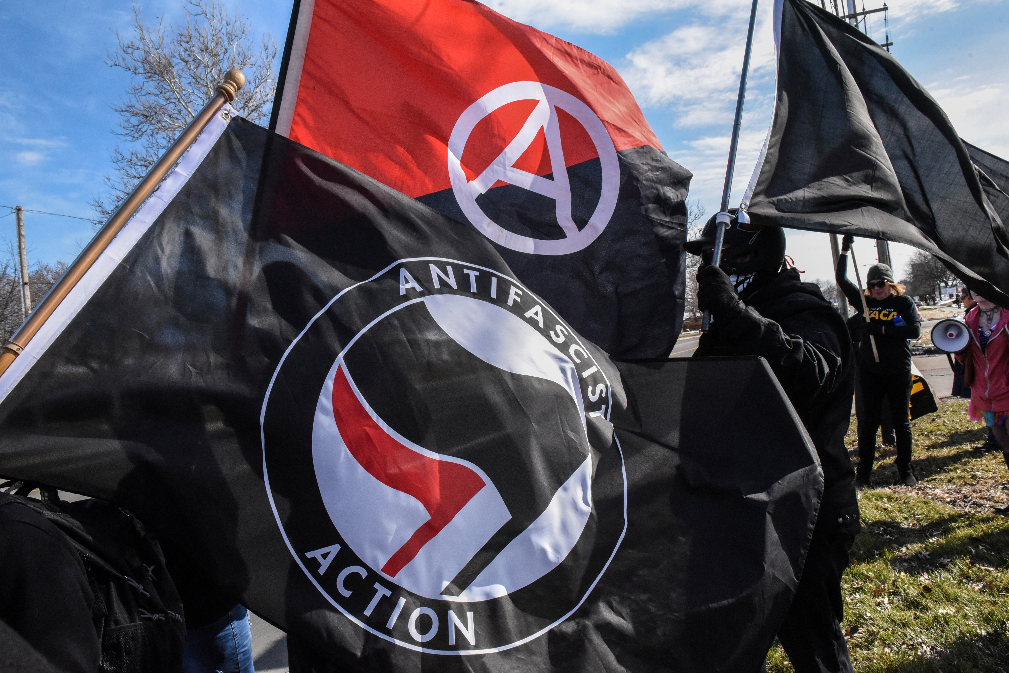 Members of the Great Lakes anti-fascist organization (Antifa) fly flags during a protest against the Alt-right outside a hotel in Warren, Michigan