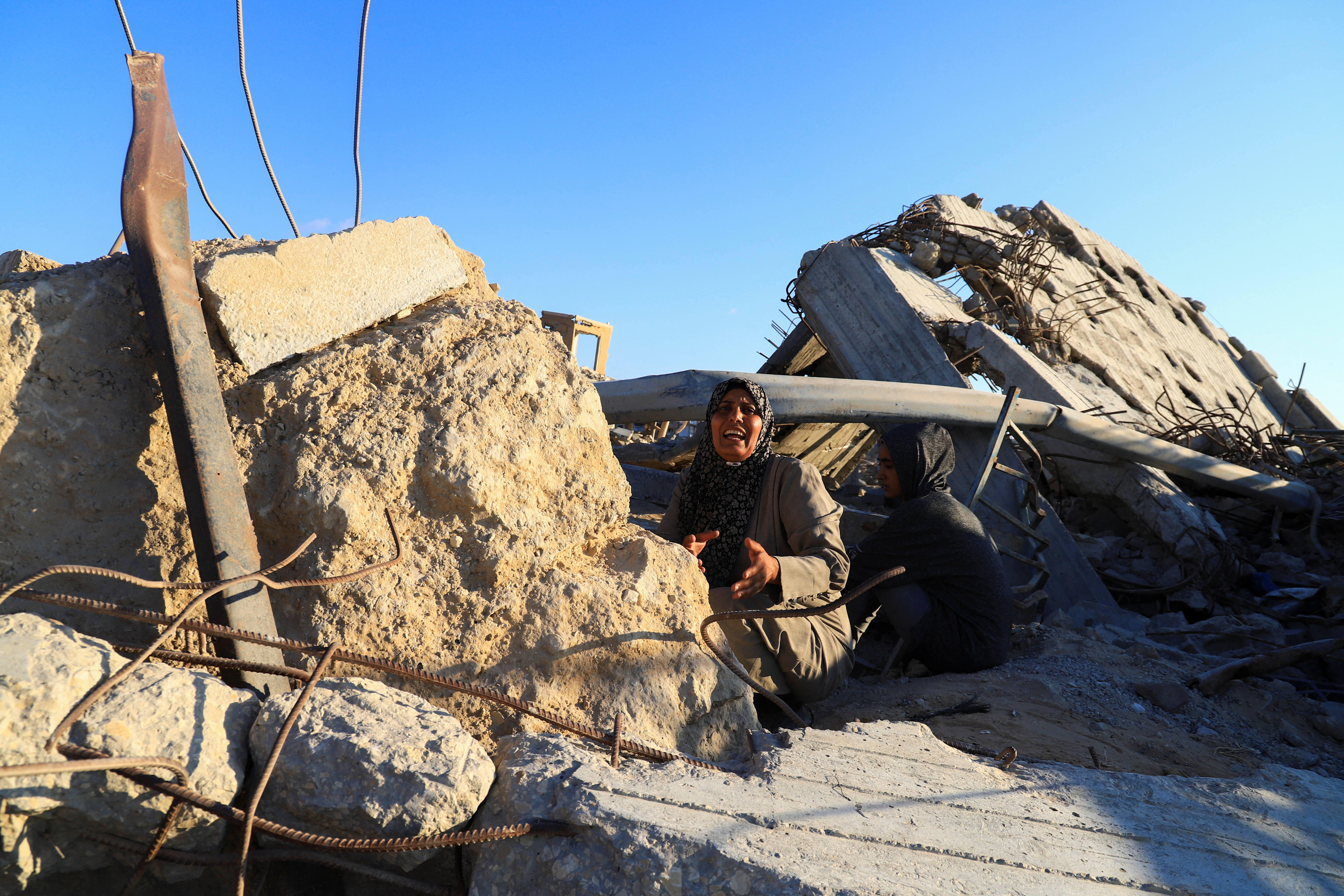 A Palestinian woman, Hind Al-Nawajha, waits for the United Nations aid trucks entering northern Gaza, in Beit Lahia, in the northern Gaza Strip
