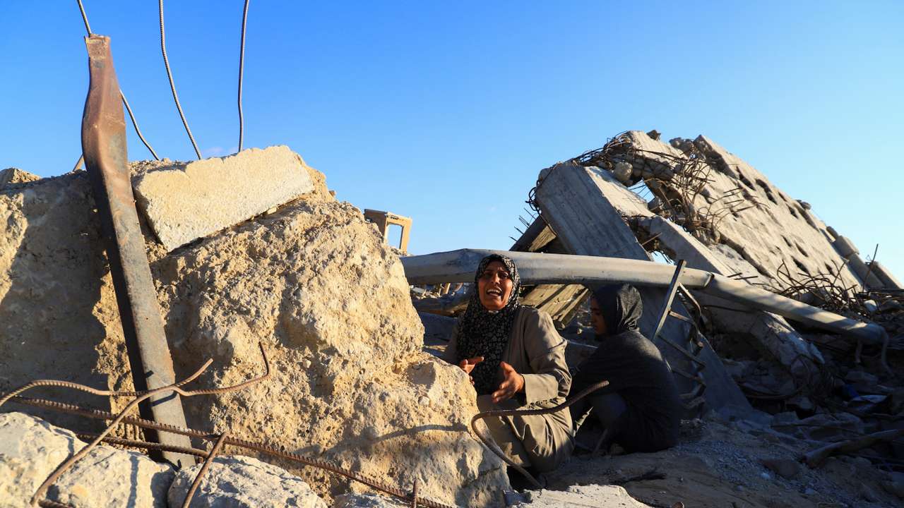 A Palestinian woman, Hind Al-Nawajha, waits for the United Nations aid trucks entering northern Gaza, in Beit Lahia, in the northern Gaza Strip