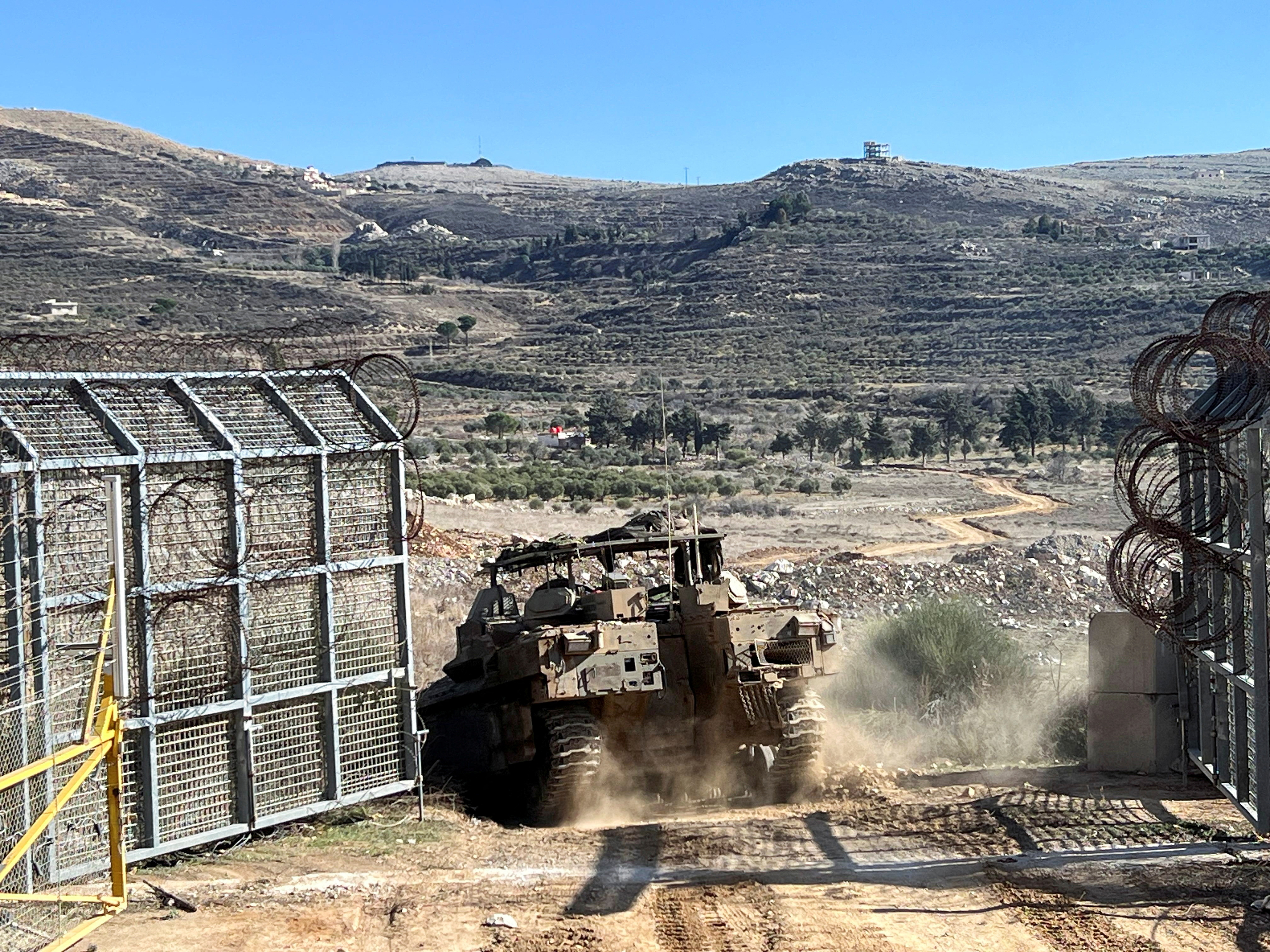 An Israeli APC enters Syria at the ceasefire line with Syria and the Israeli-occupied Golan Heights, as seen from the Golan Heights