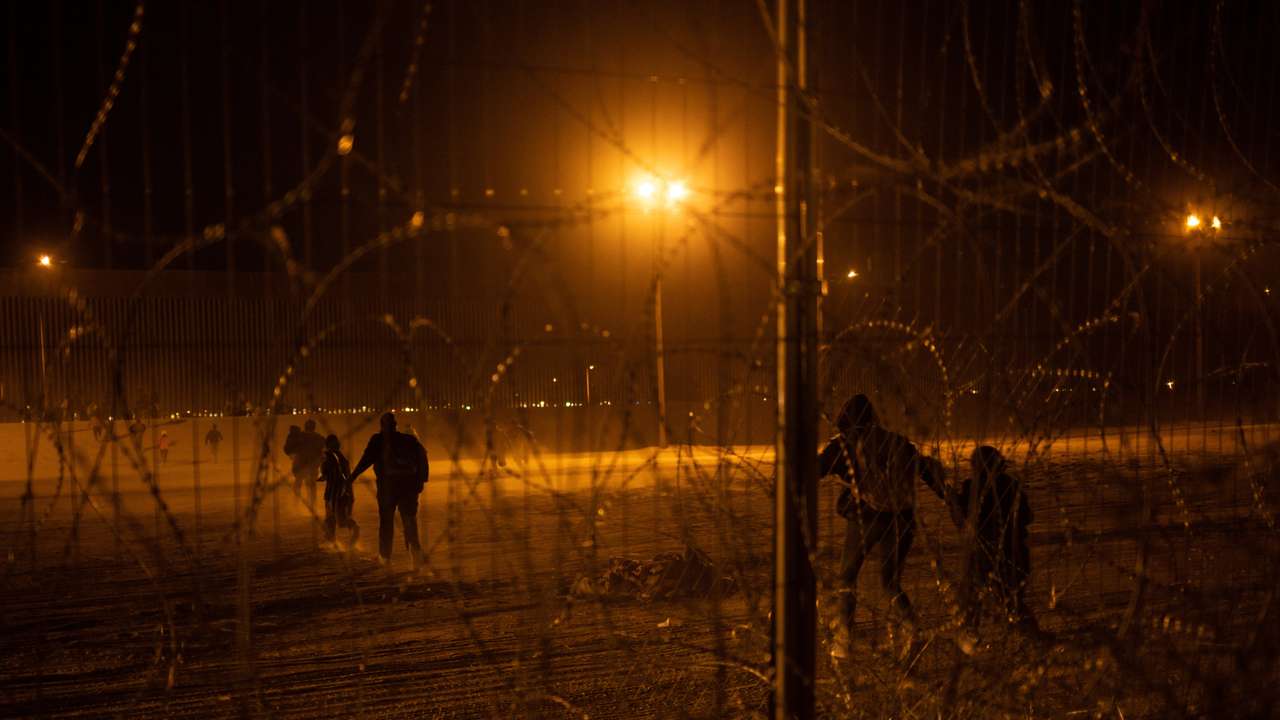 Migrants race towards border wall after breaching fence into the U.S. from Mexico