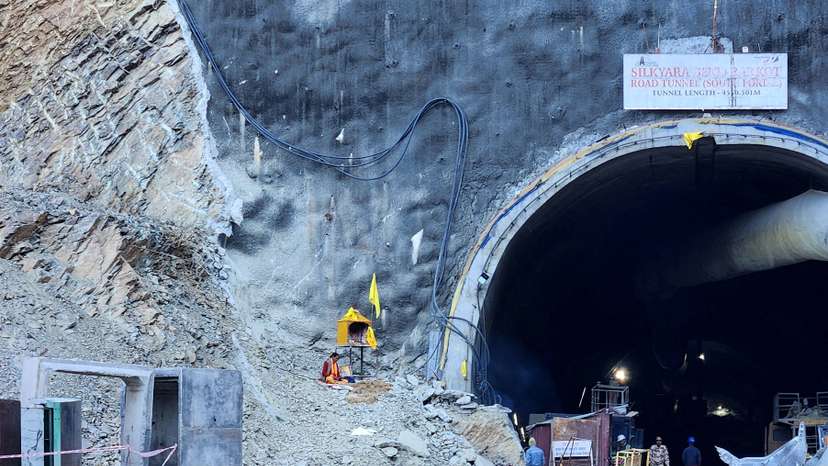 A Hindu priest prays at a makeshift shrine outside the entrance of a tunnel where workers are trapped, in Uttarkashi