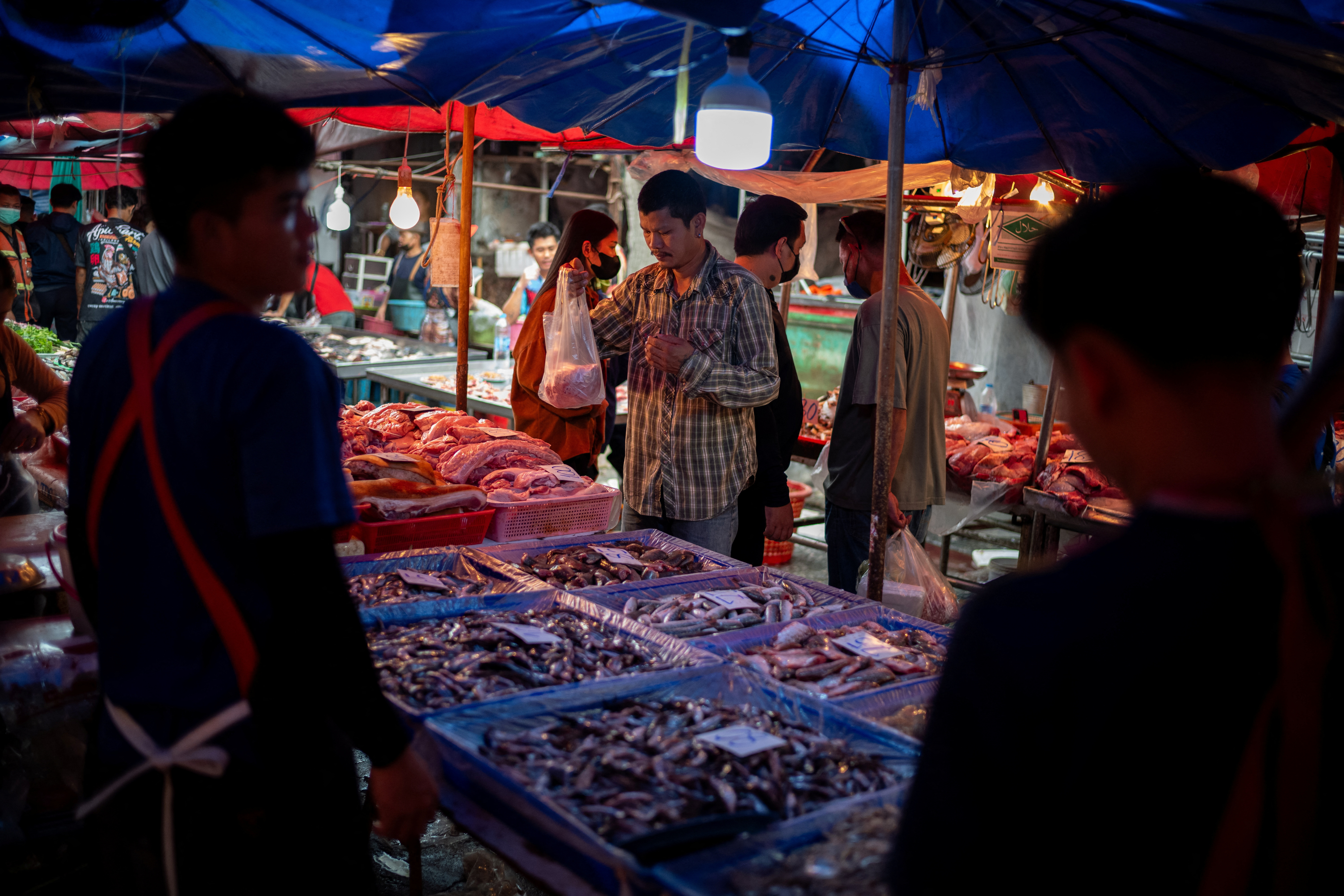 A man buys foods at a market as Thailand is to inject $15.2 bln into economy next year through its digital wallet policy, in Bangkok