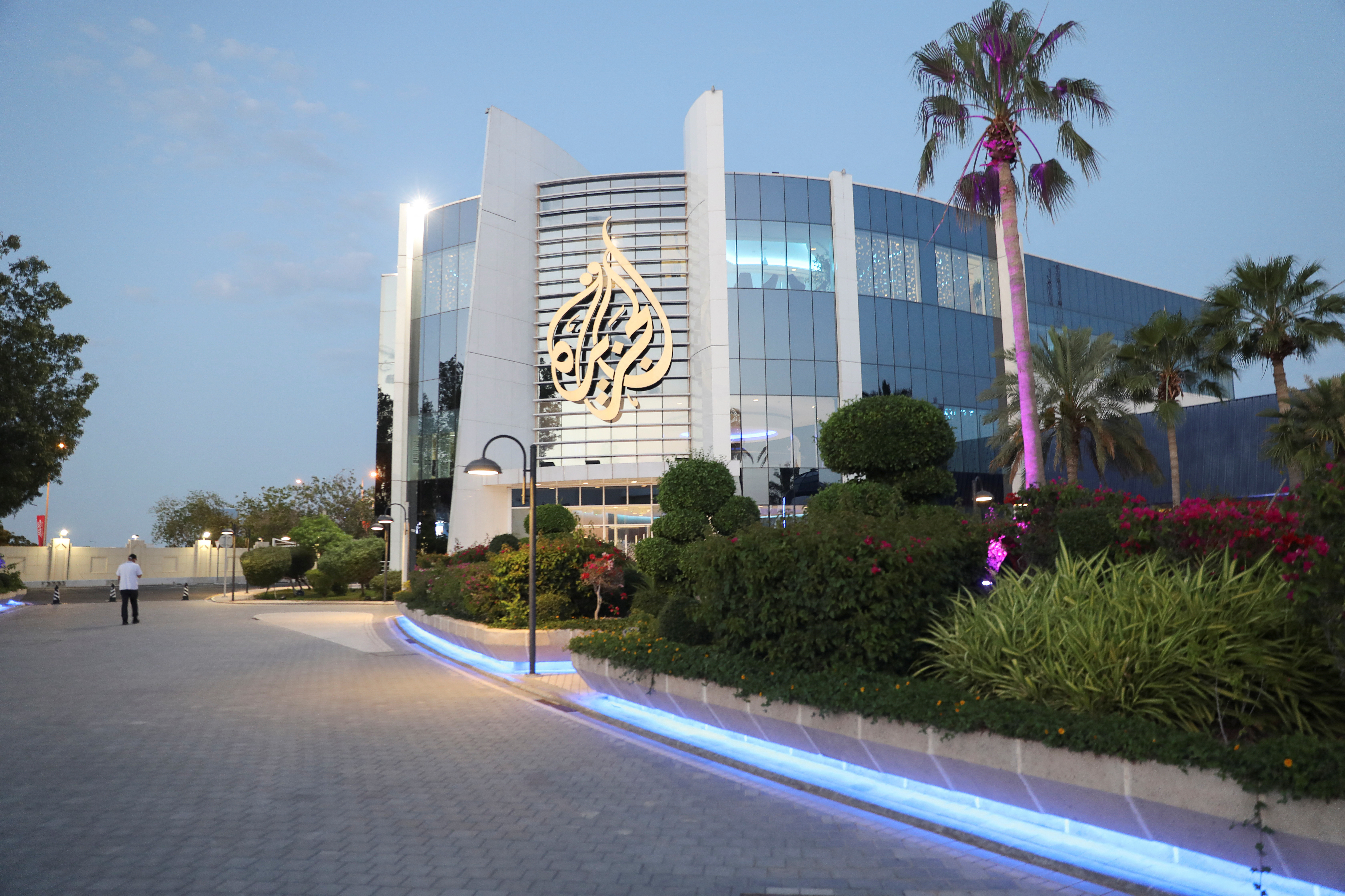 FILE PHOTO: Man walks near an Al Jazeera building in Doha