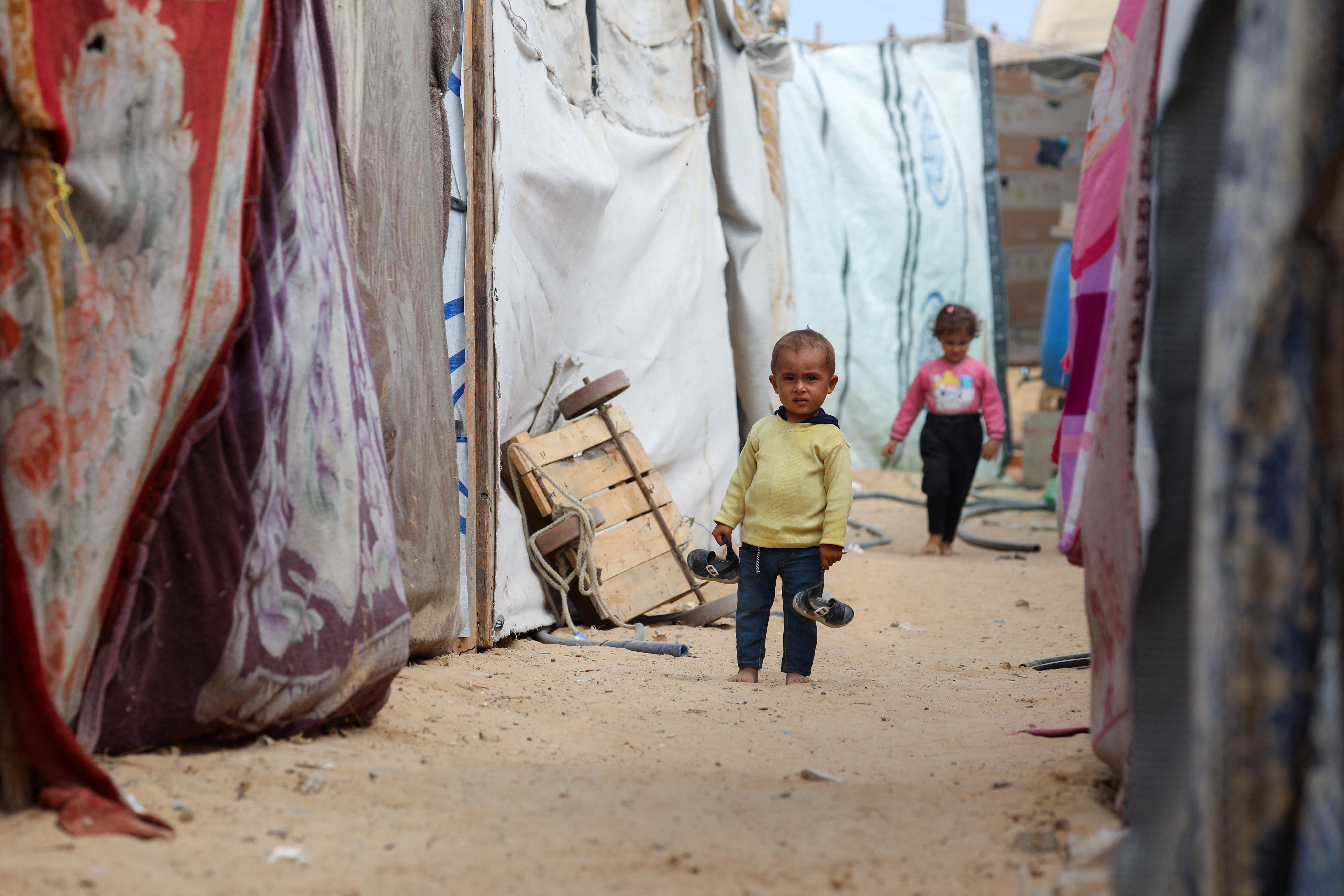 Palestinian child stands between tents as displaced Palestinians who fled northern Gaza shelter in the central Gaza Strip
