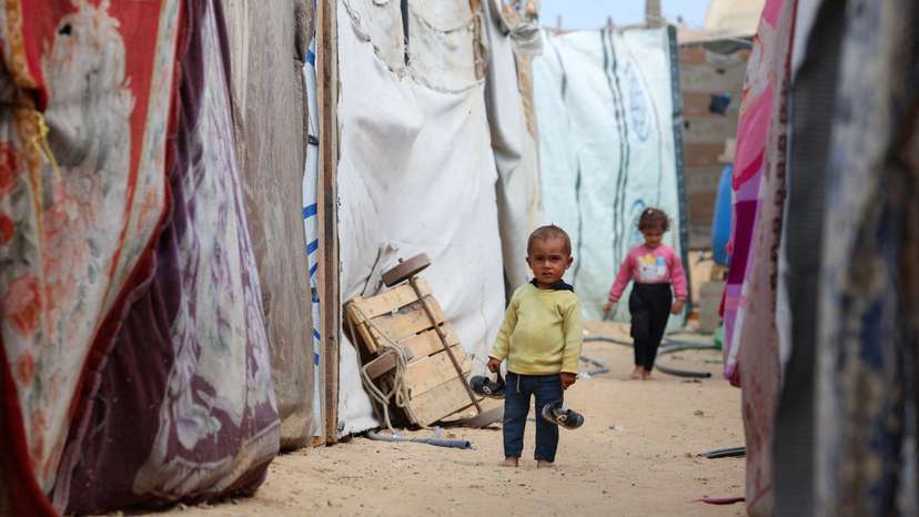 Palestinian child stands between tents as displaced Palestinians who fled northern Gaza shelter in the central Gaza Strip