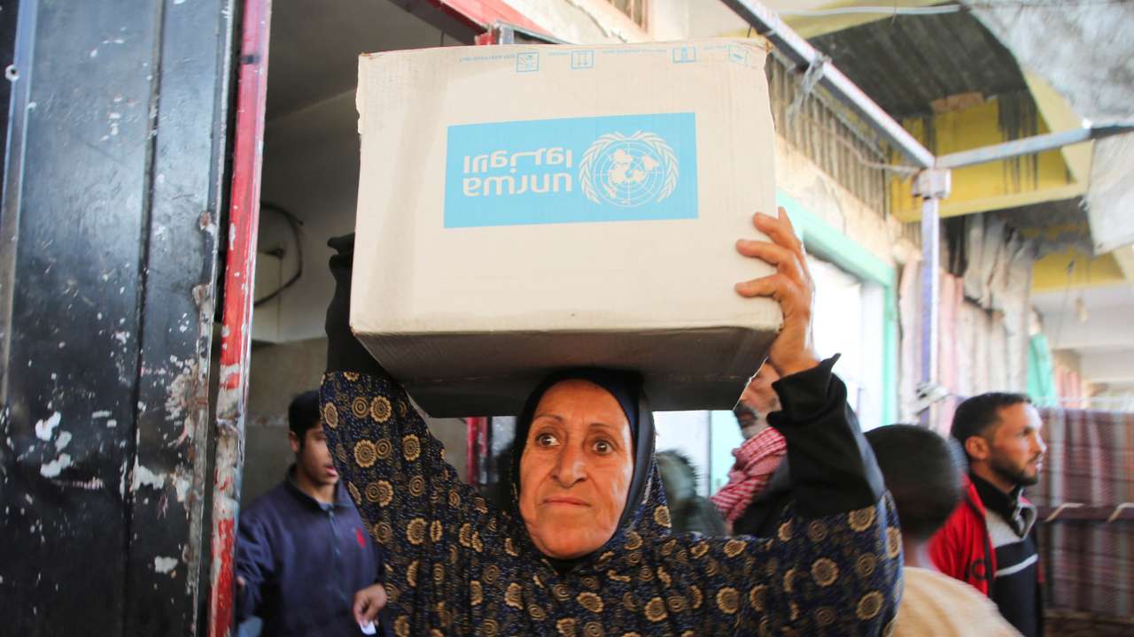 Palestinians receive aid following a ceasefire between Israel and Hamas, in Khan Younis in the southern Gaza Strip
