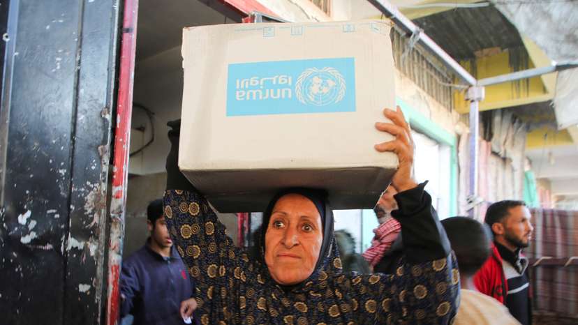 Palestinians receive aid following a ceasefire between Israel and Hamas, in Khan Younis in the southern Gaza Strip