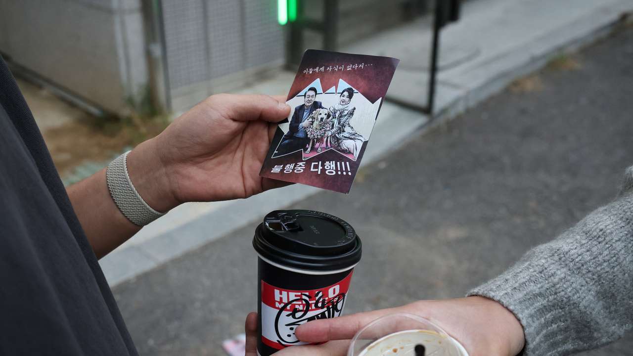 People look at a North Korean propaganda leaflet denouncing South Korean President Yoon Suk Yeol and his wife Kim Keon Hee, apparently carried by balloons sent from North Korea, near the Presidential Office, in Seoul