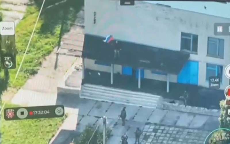 Armed personnel pull down a Russian national flag hoisted on a building, following an incursion of Ukrainian troops in the course of Russia-Ukraine conflict, in Vnezapnoe