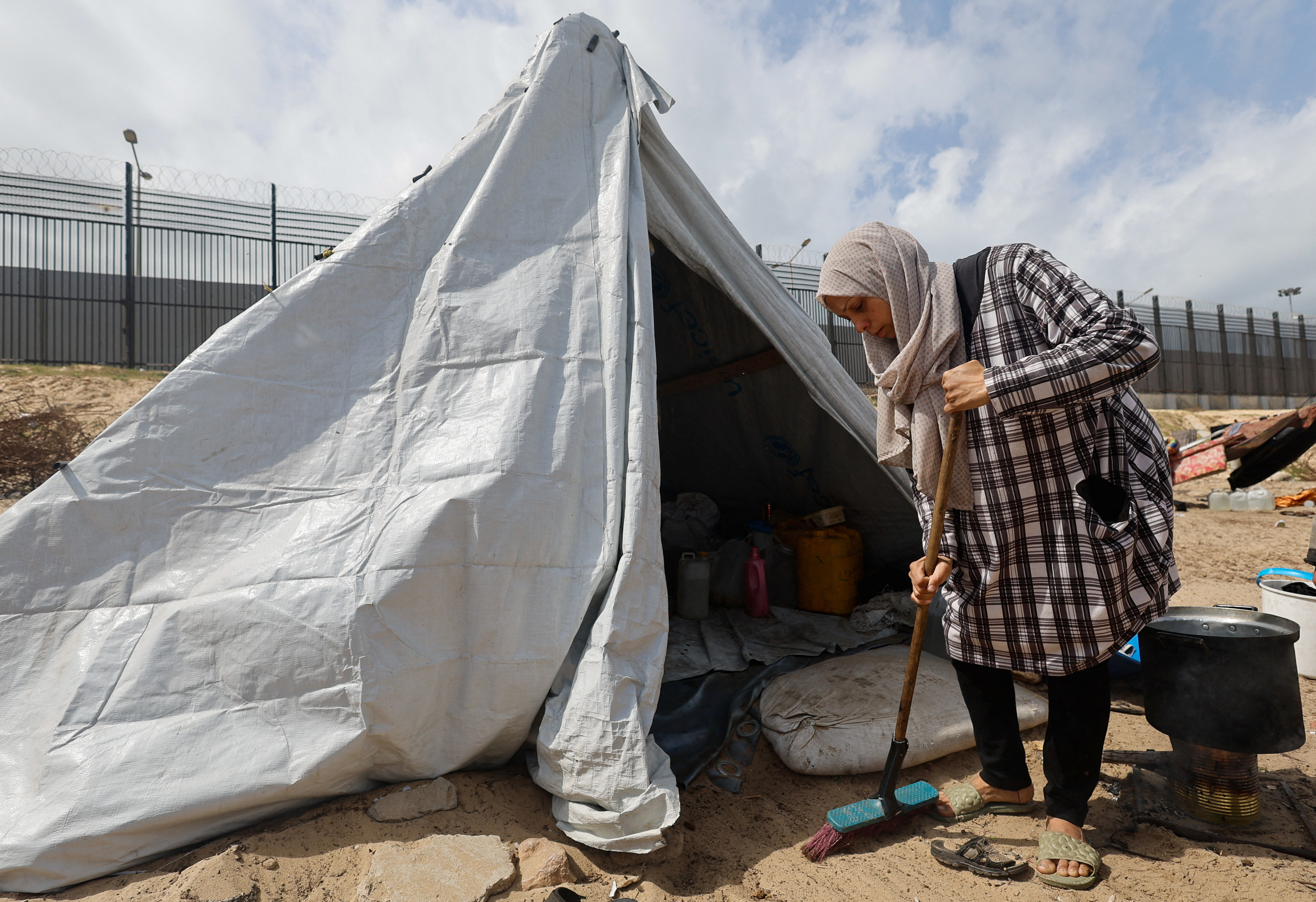 Displaced Palestinian women, who fled their houses due to Israeli strikes shelter in a tent camp, in Rafah