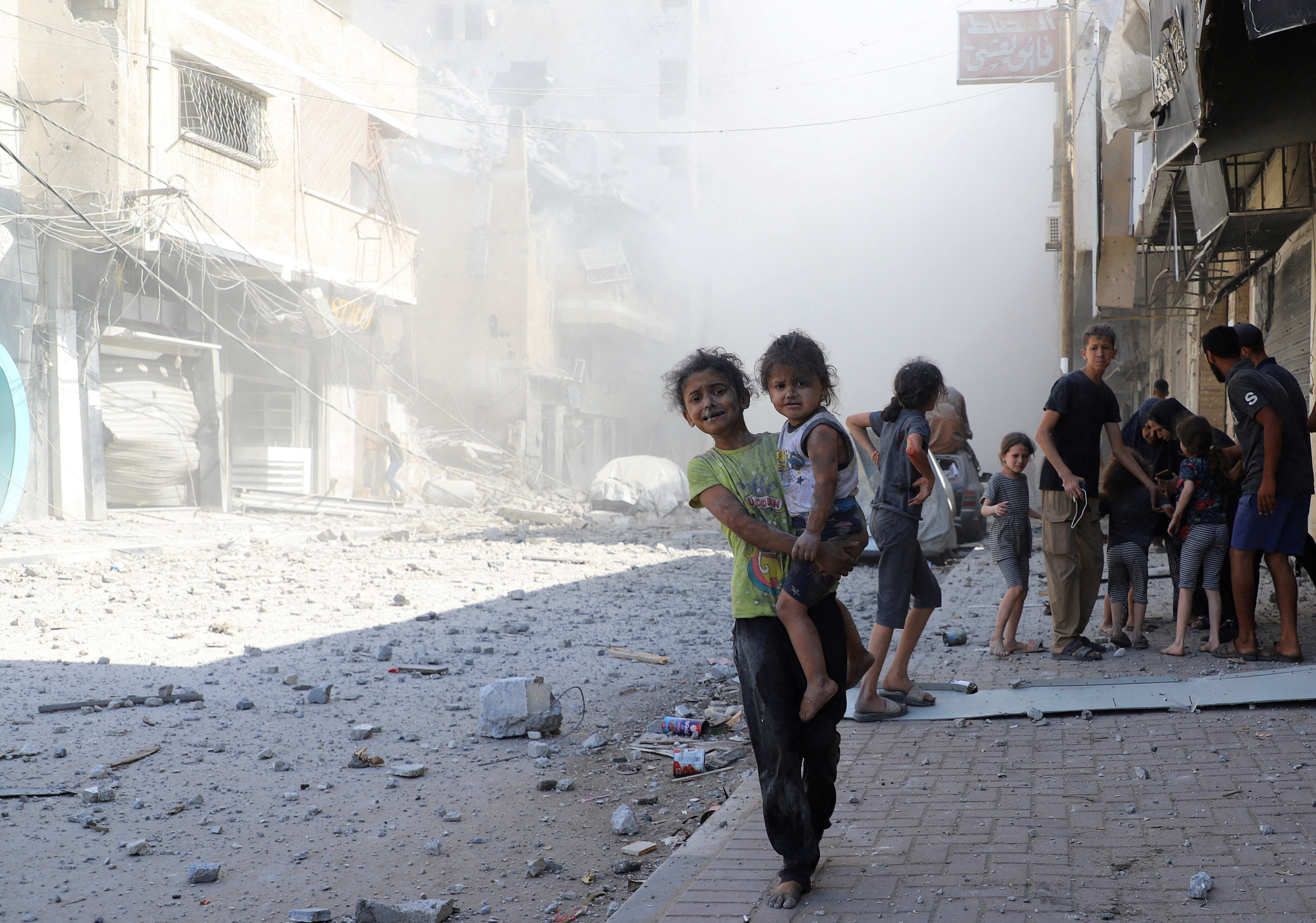 Palestinians inspect the site of Israeli strikes on a house, in Gaza City