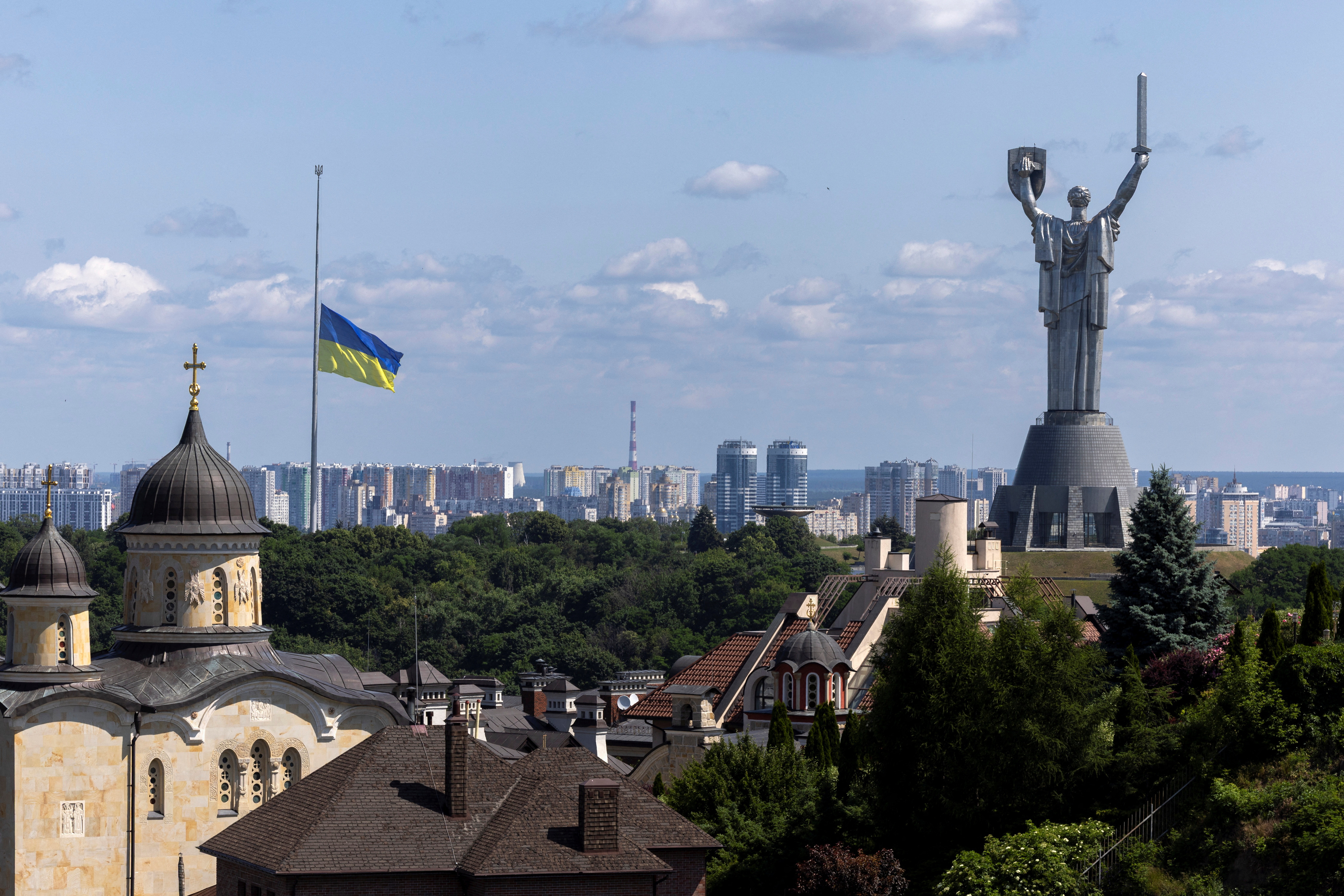 Ukrainian national flag flies at half-mast near the Ukrainian Motherland Monument after Tuesday’s deadly Russian missile strike in Kyiv