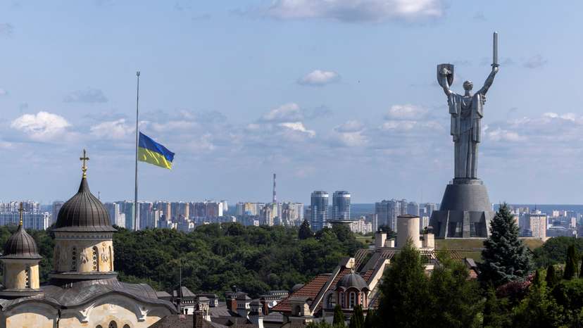 Ukrainian national flag flies at half-mast near the Ukrainian Motherland Monument after Tuesday’s deadly Russian missile strike in Kyiv