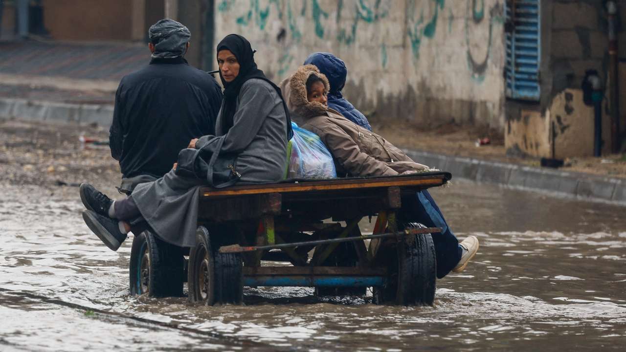 Displaced Palestinians shelter in a tent camp, on a rainy day in Nuseirat