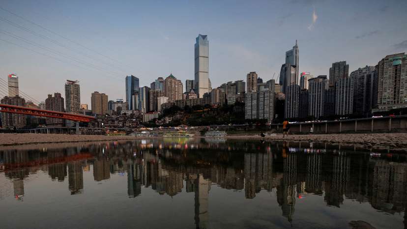 FILE PHOTO: The city skyline is reflected in a pool left on the dry riverbed of the receding Jialing river, a tributary of the Yangtze, that is approaching record-low water levels during a regional drought in Chongqing