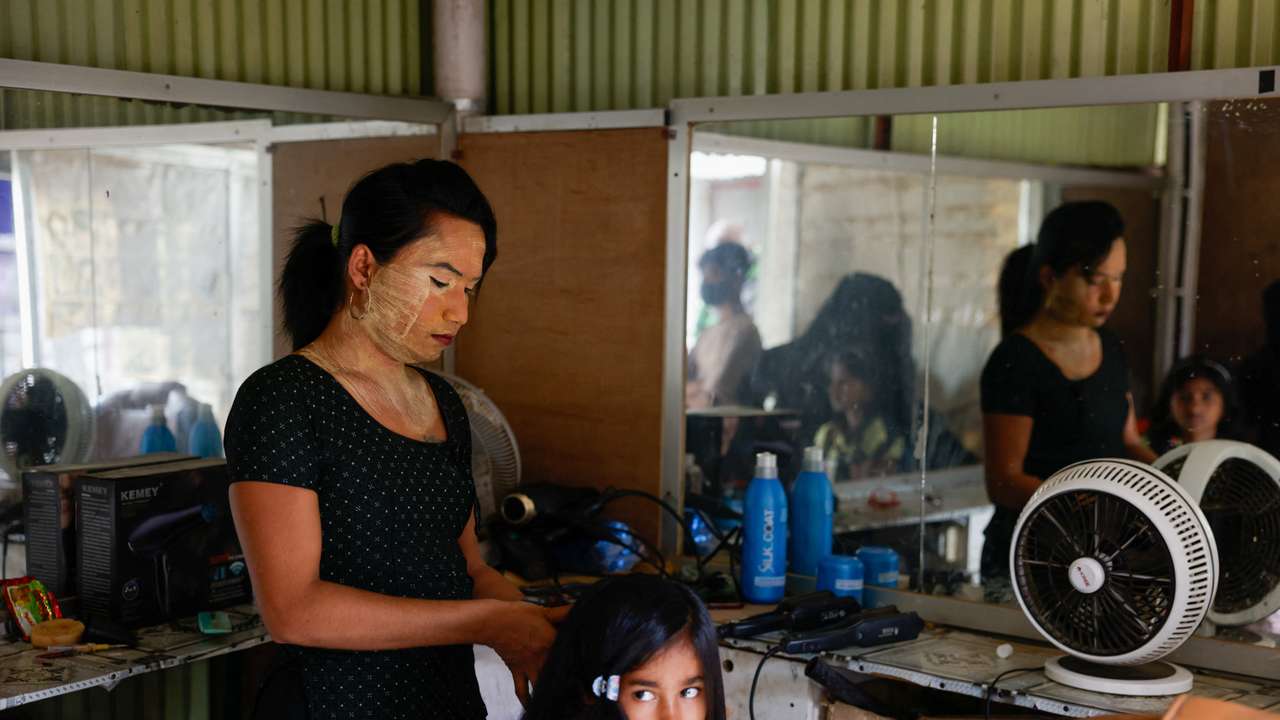 Tanya, 25, a Rohingya transgender beautician, provides service to a young girl in her beauty parlour, at the entrance of the Kutupalong refugee camp, in Cox's Bazar