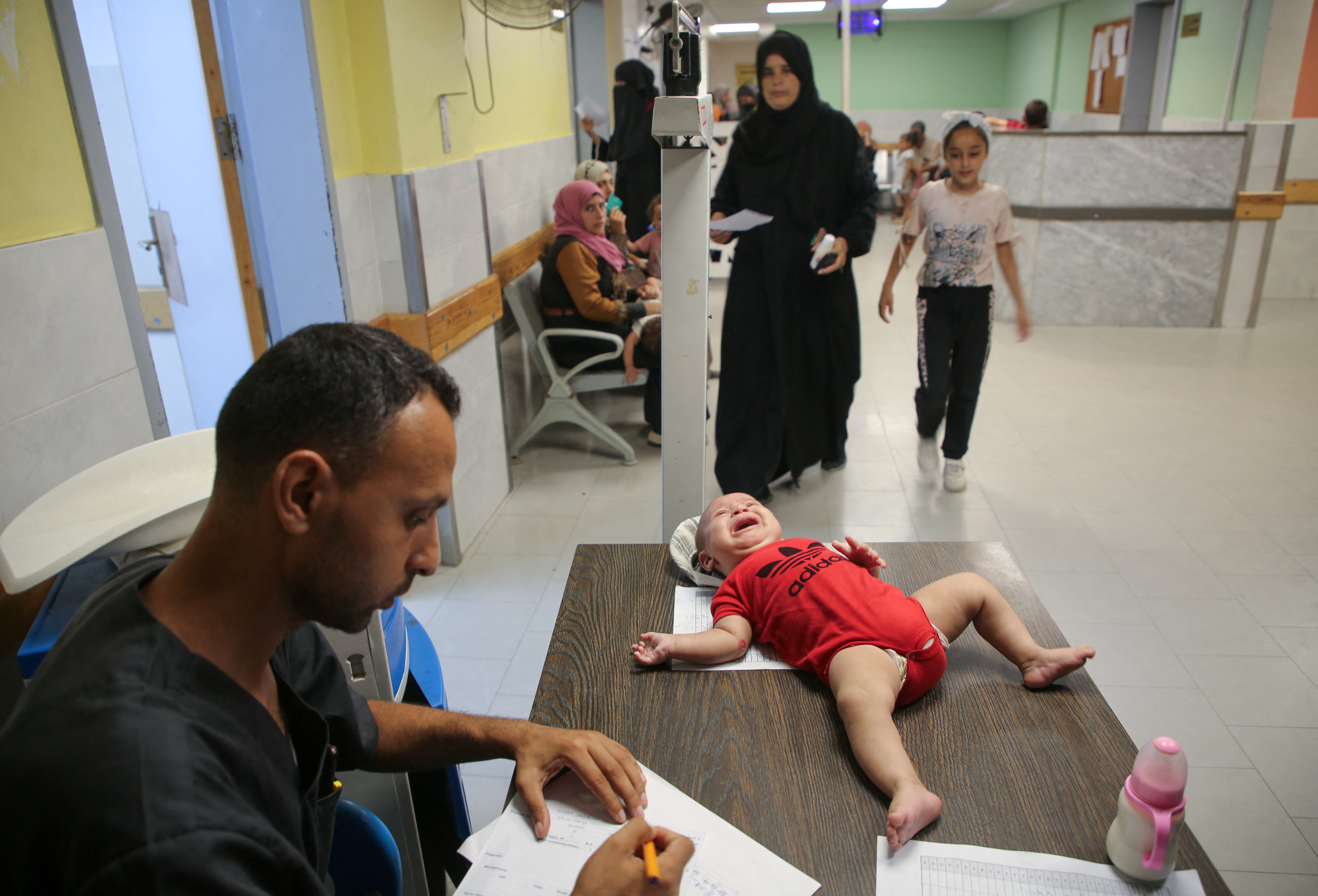 Palestinian children are examined by a doctor at Nasser hospital