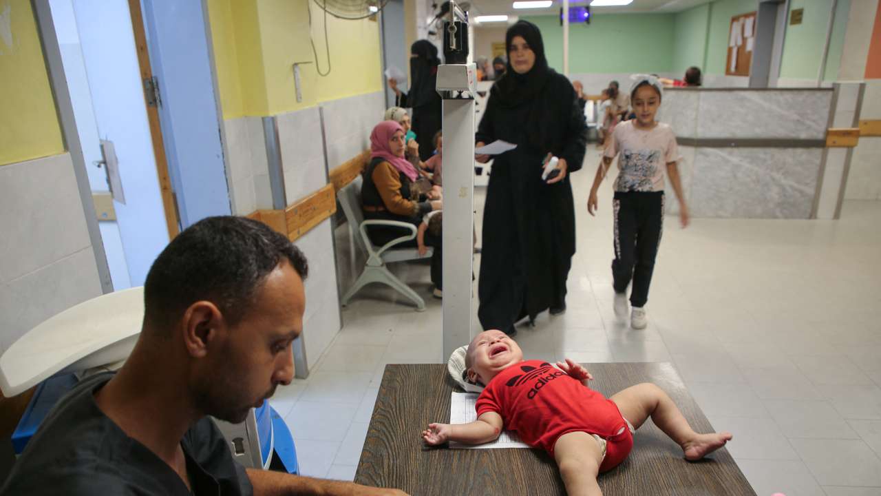 Palestinian children are examined by a doctor at Nasser hospital