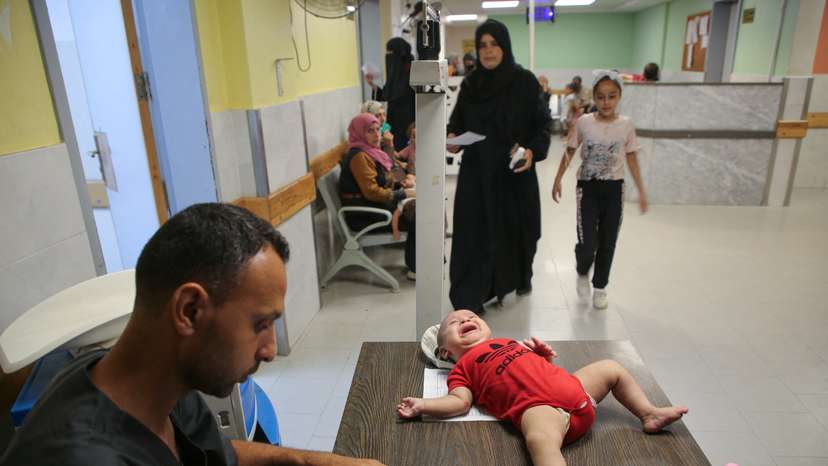 Palestinian children are examined by a doctor at Nasser hospital