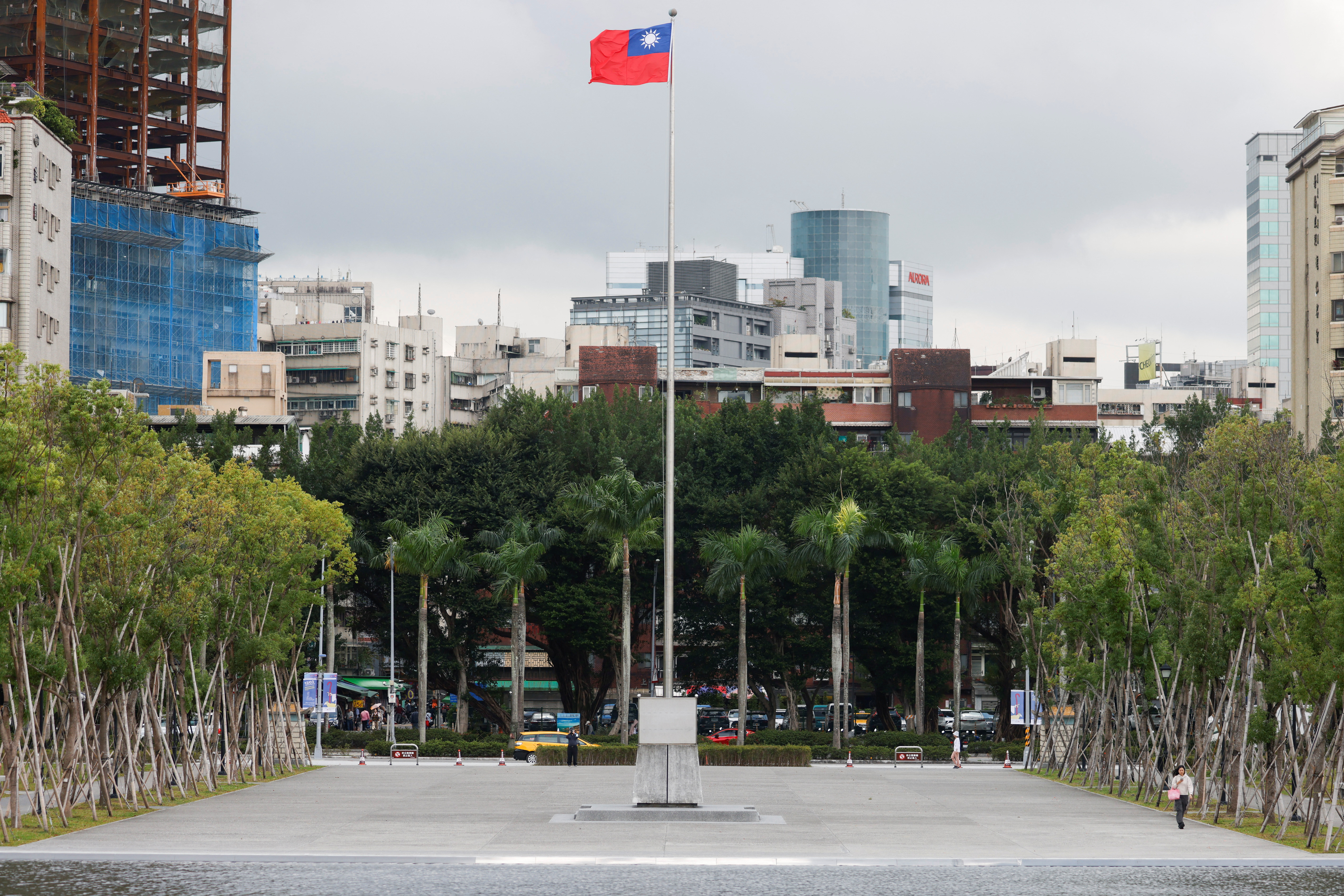 A person walks next to a fluttering Taiwanese flag outside the Sun Yat-Sen Memorial Hall in Taipei