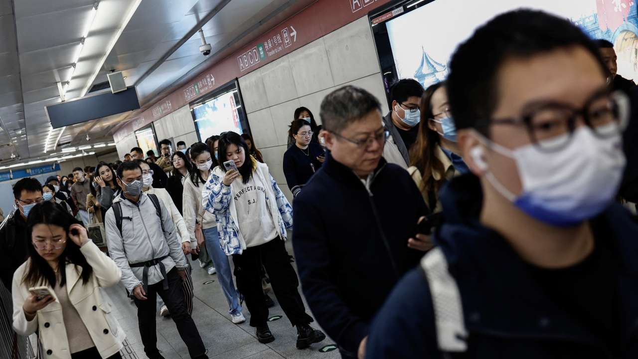 People walk at a subway station during morning rush hour in Beijing