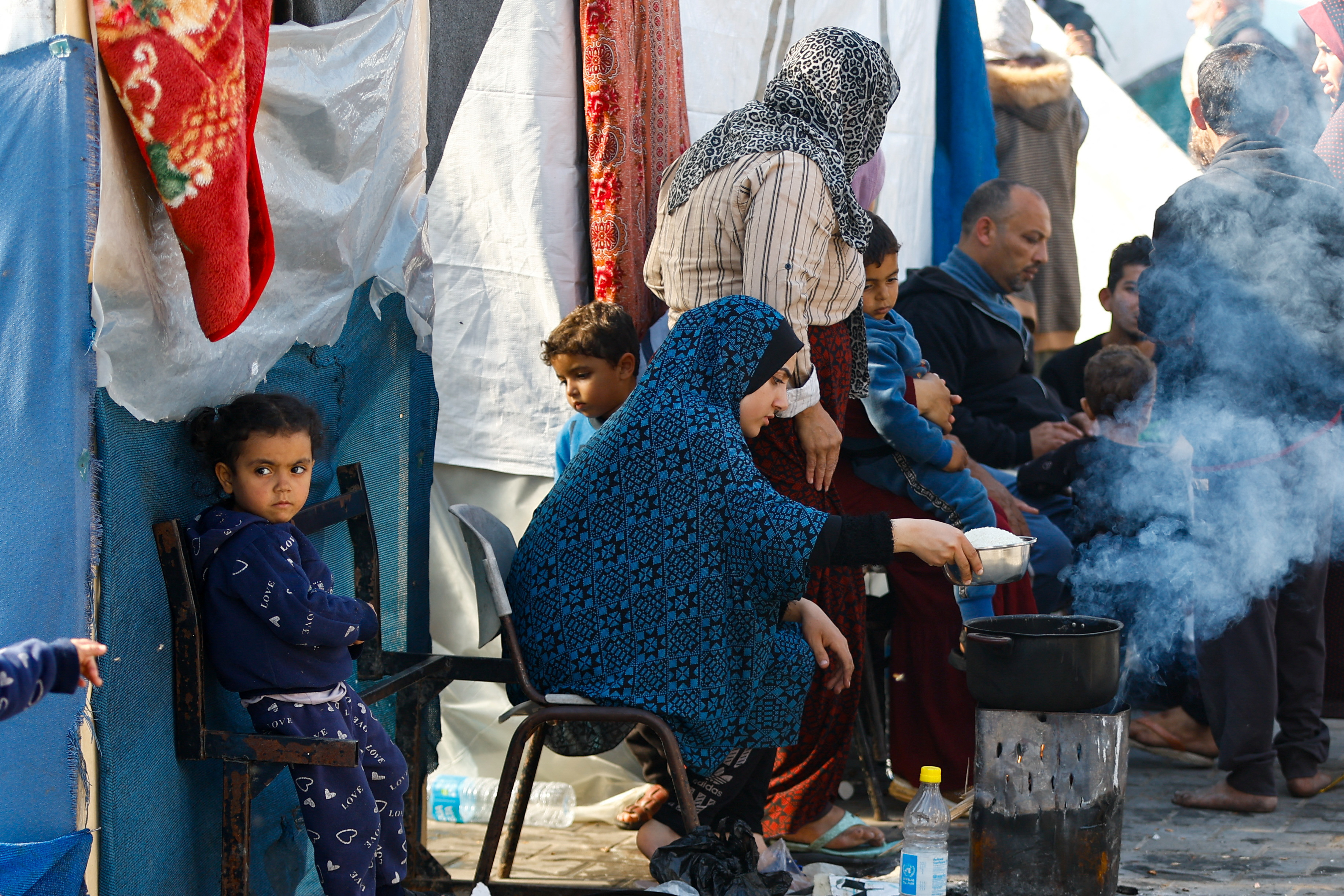 FILE PHOTO: Palestinians, who fled their houses amid Israeli strikes, shelter at a United Nations-run school, in Khan Younis