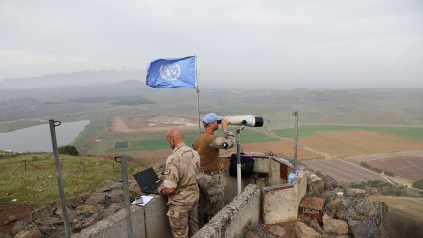 FILE PHOTO: UN soldiers look out on a post at Mount Avital, in the Israeli-occupied Golan Heights near the Israeli Syrian border