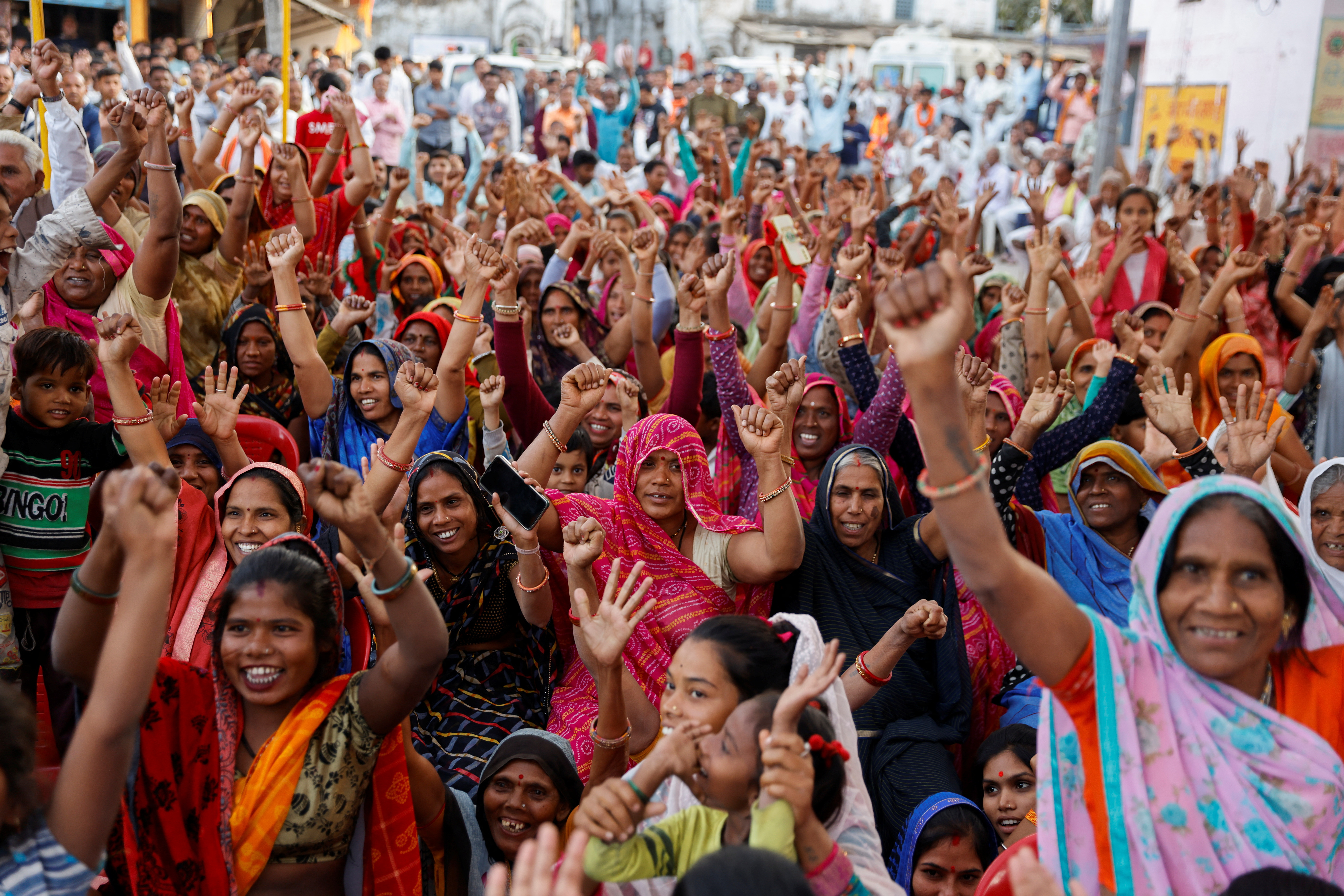 Women raise hands at an event where the senior Bharatiya Janata Party (BJP) leader Shivraj Singh Chouhan was visiting, in the village Ladkui near Bhopal