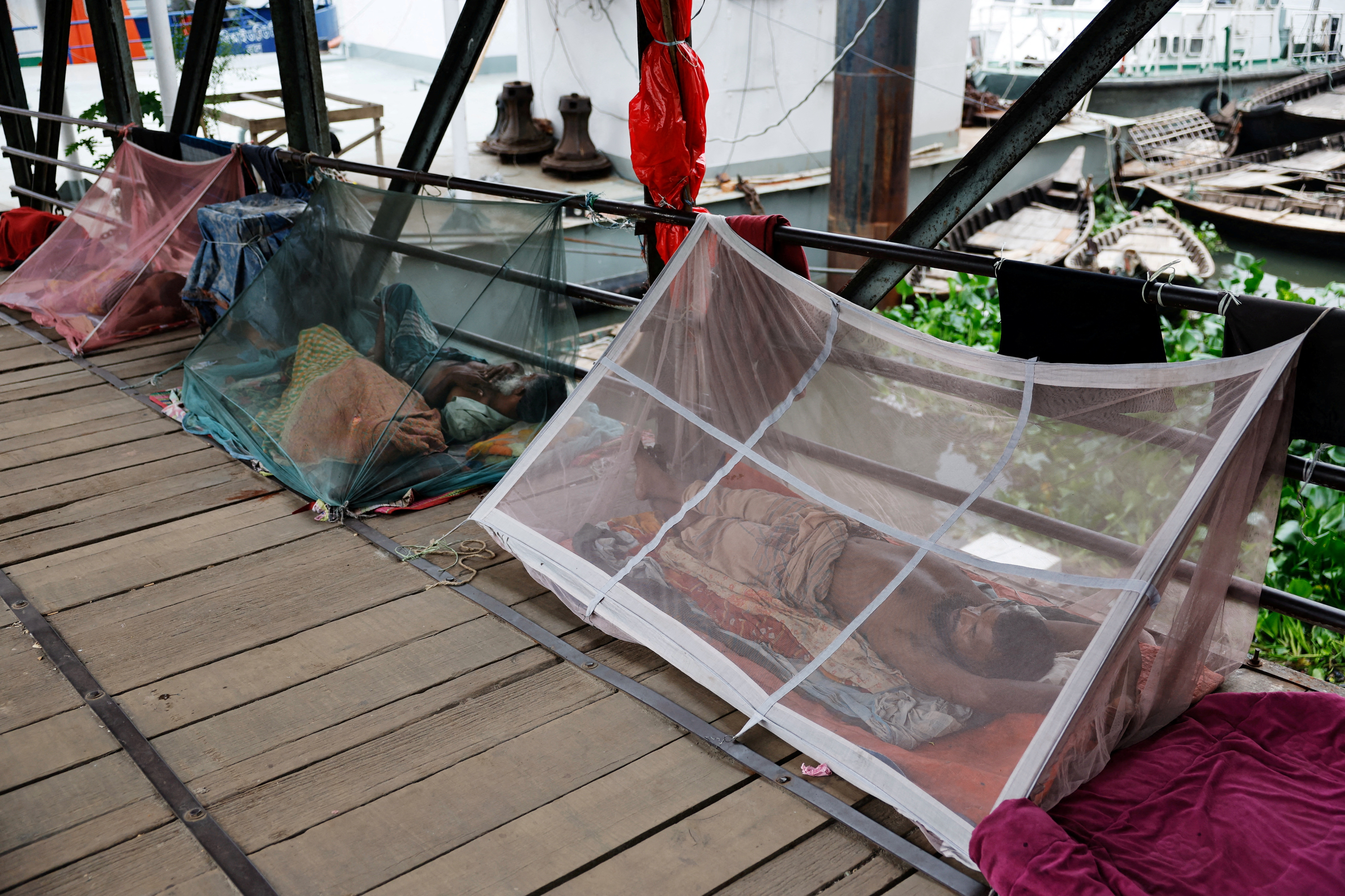 FILE PHOTO: People sleep using mosquito nets, following a surge of dengue infected patient, in Dhaka