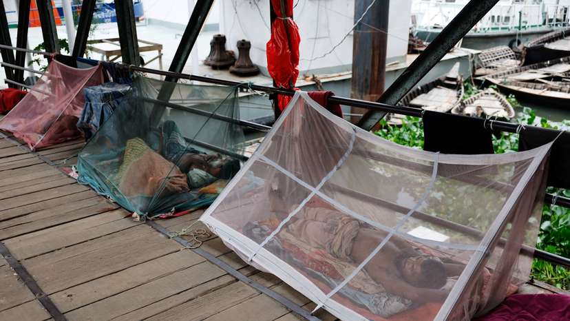 FILE PHOTO: People sleep using mosquito nets, following a surge of dengue infected patient, in Dhaka