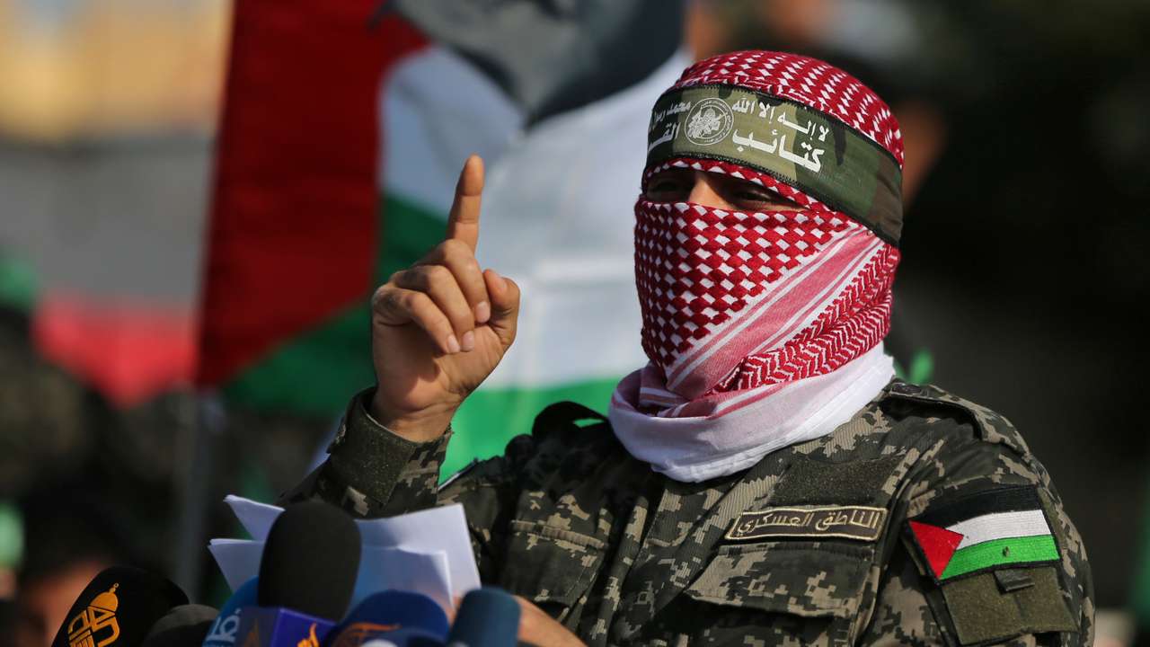 Abu Ubaida, the spokesman of the Izz el-Deen al-Qassam Brigades, gestures as he speaks during an anti-Israel military show in the southern Gaza Strip