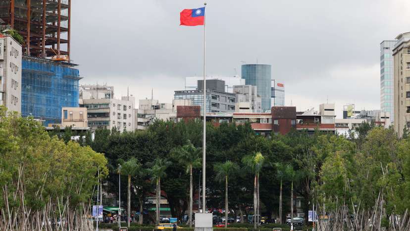 A person walks next to a fluttering Taiwanese flag outside the Sun Yat-Sen Memorial Hall in Taipei