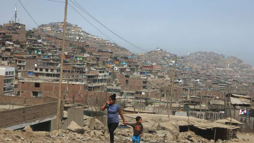 A woman and child walk on the hills of Villa Maria del Triunfo, a shanty town on the outskirts of Lima