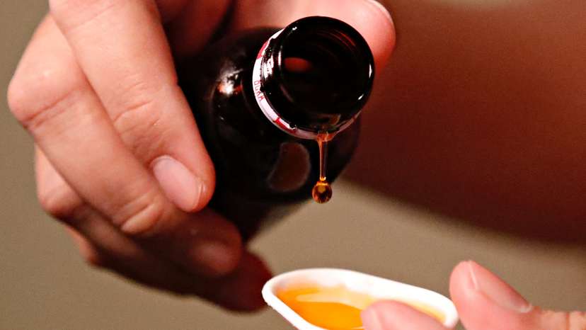 A cough medication is poured in this picture illustration