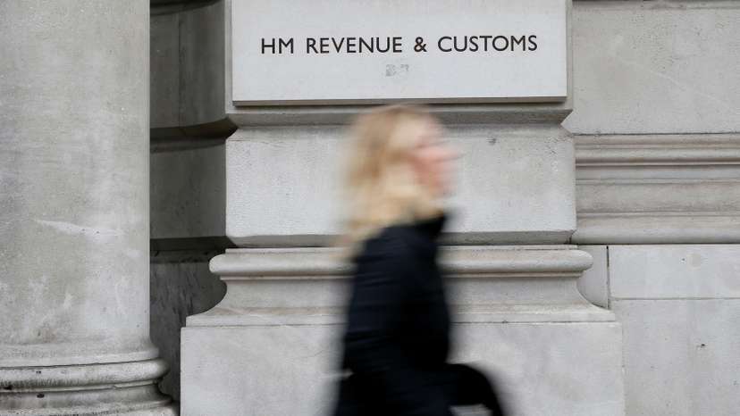 FILE PHOTO: A pedestrian walks past the headquarters of Her Majesty's Revenue and Customs (HMRC) in central London