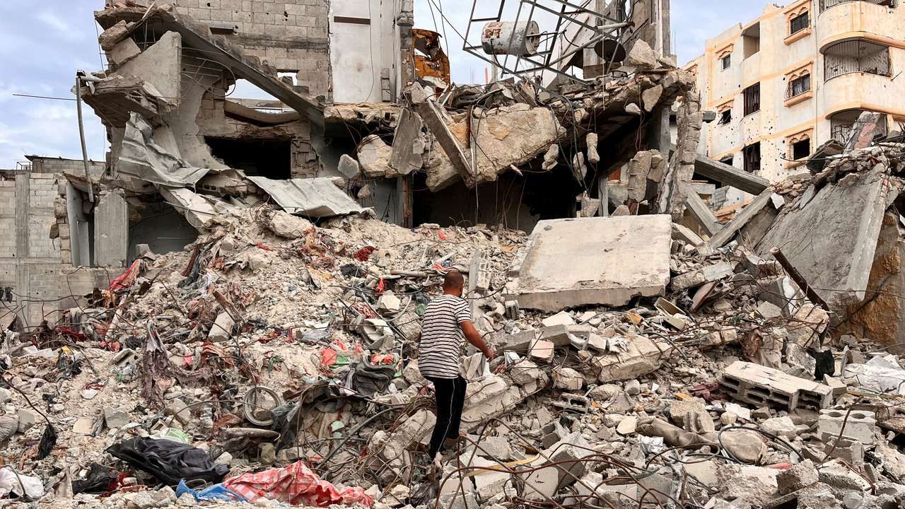 Palestinian man Moein Abu Odeh searches for clothes through the rubble of a house destroyed in the Israeli military offensive, in Khan Younis in the southern Gaza Strip