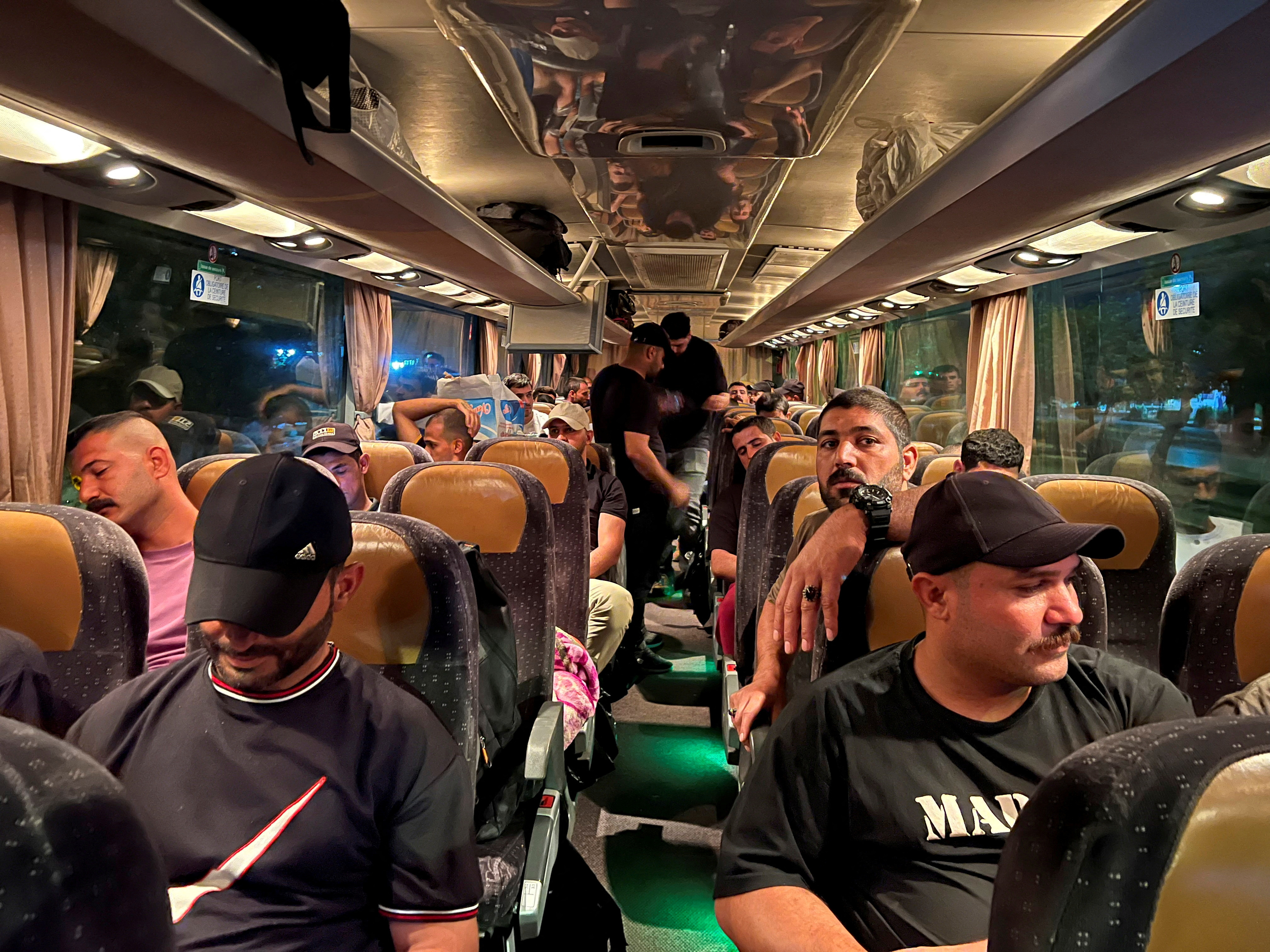 FILE PHOTO: Supporters of Iraq's Popular Mobilisation Forces (PMF), ride in a bus heading to Iraq's main border crossing with Jordan to express solidarity with Gaza, in Baghdad