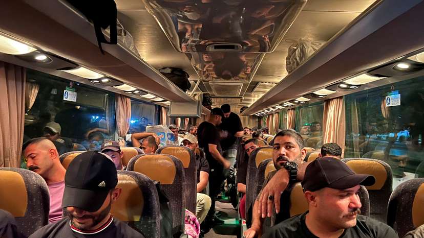 FILE PHOTO: Supporters of Iraq's Popular Mobilisation Forces (PMF), ride in a bus heading to Iraq's main border crossing with Jordan to express solidarity with Gaza, in Baghdad