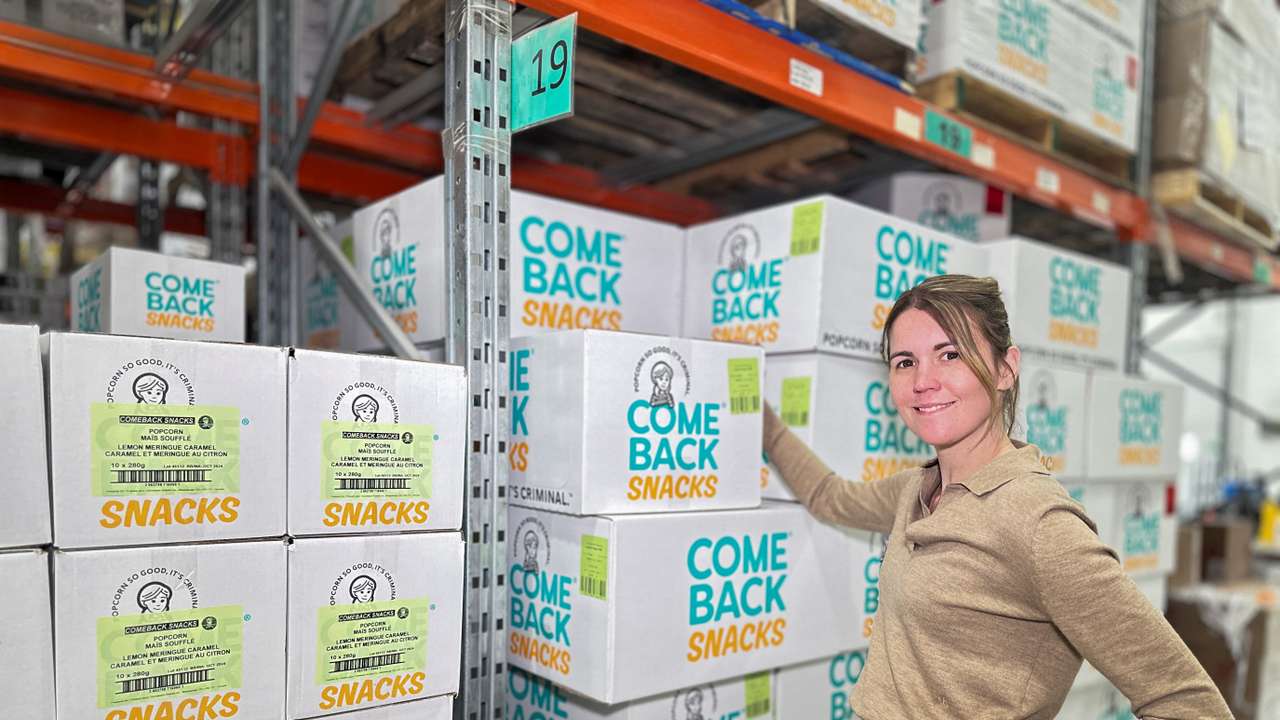 CEO of Comeback Snacks Emily O'Brien poses near snack boxes at her warehouse in Vaughan, Ontario