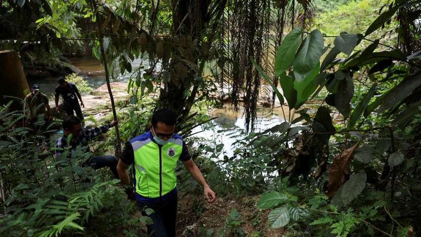 FILE PHOTO: Immigration officers check a riverine area near an immigration detention centre where more than 100 Myanmar migrants, including Rohingya refugees, escaped, at Bidor