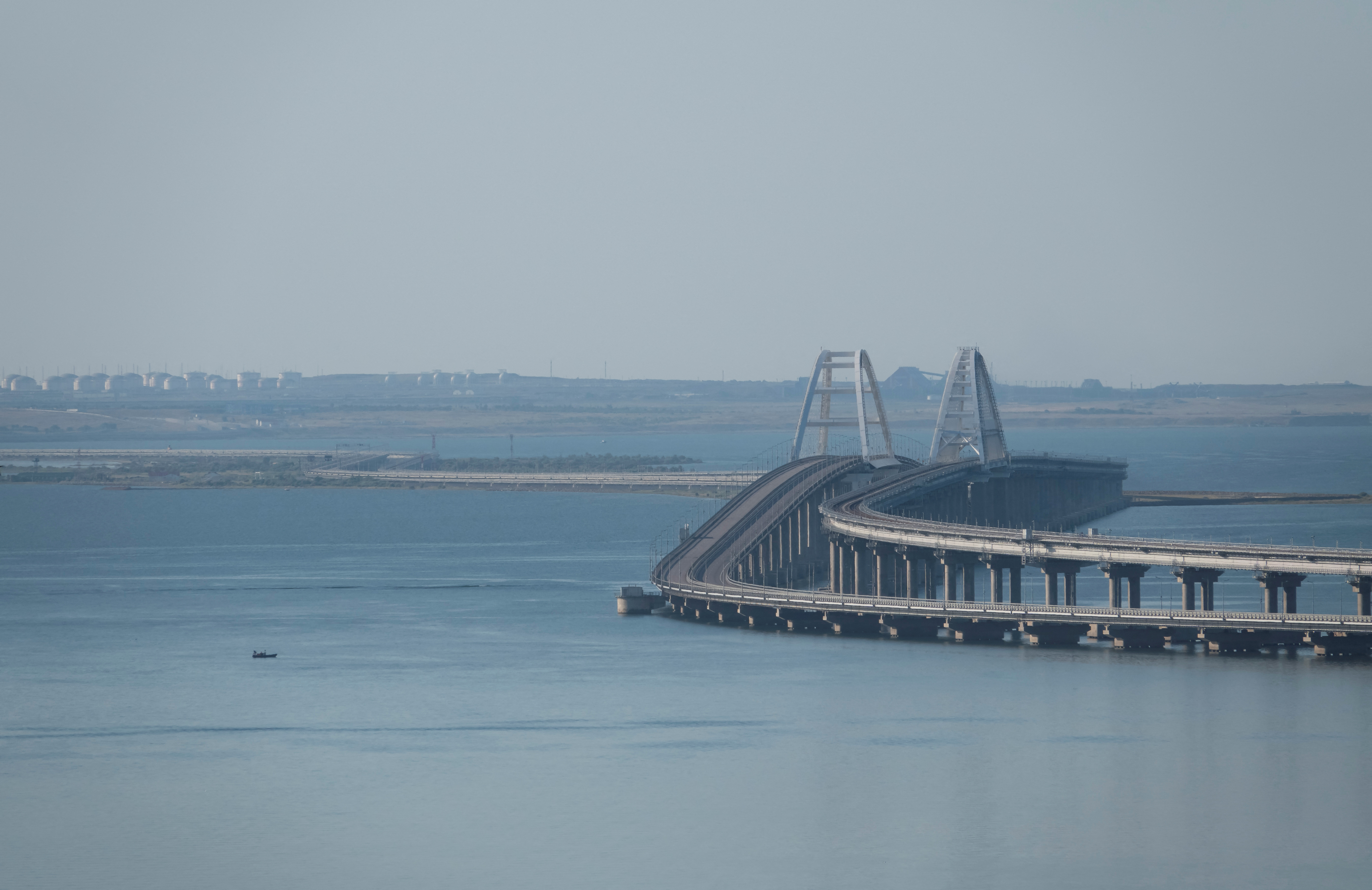 A boat sails next to the Crimean bridge connecting the Russian mainland with the peninsula across the Kerch Strait