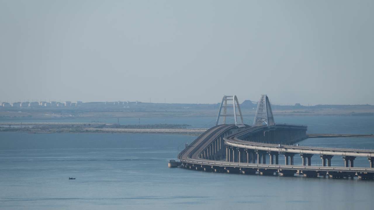 A boat sails next to the Crimean bridge connecting the Russian mainland with the peninsula across the Kerch Strait