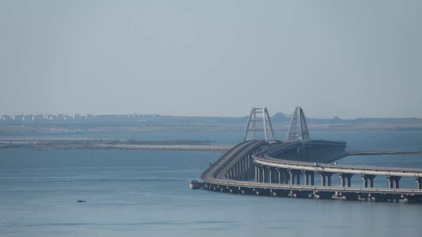 A boat sails next to the Crimean bridge connecting the Russian mainland with the peninsula across the Kerch Strait