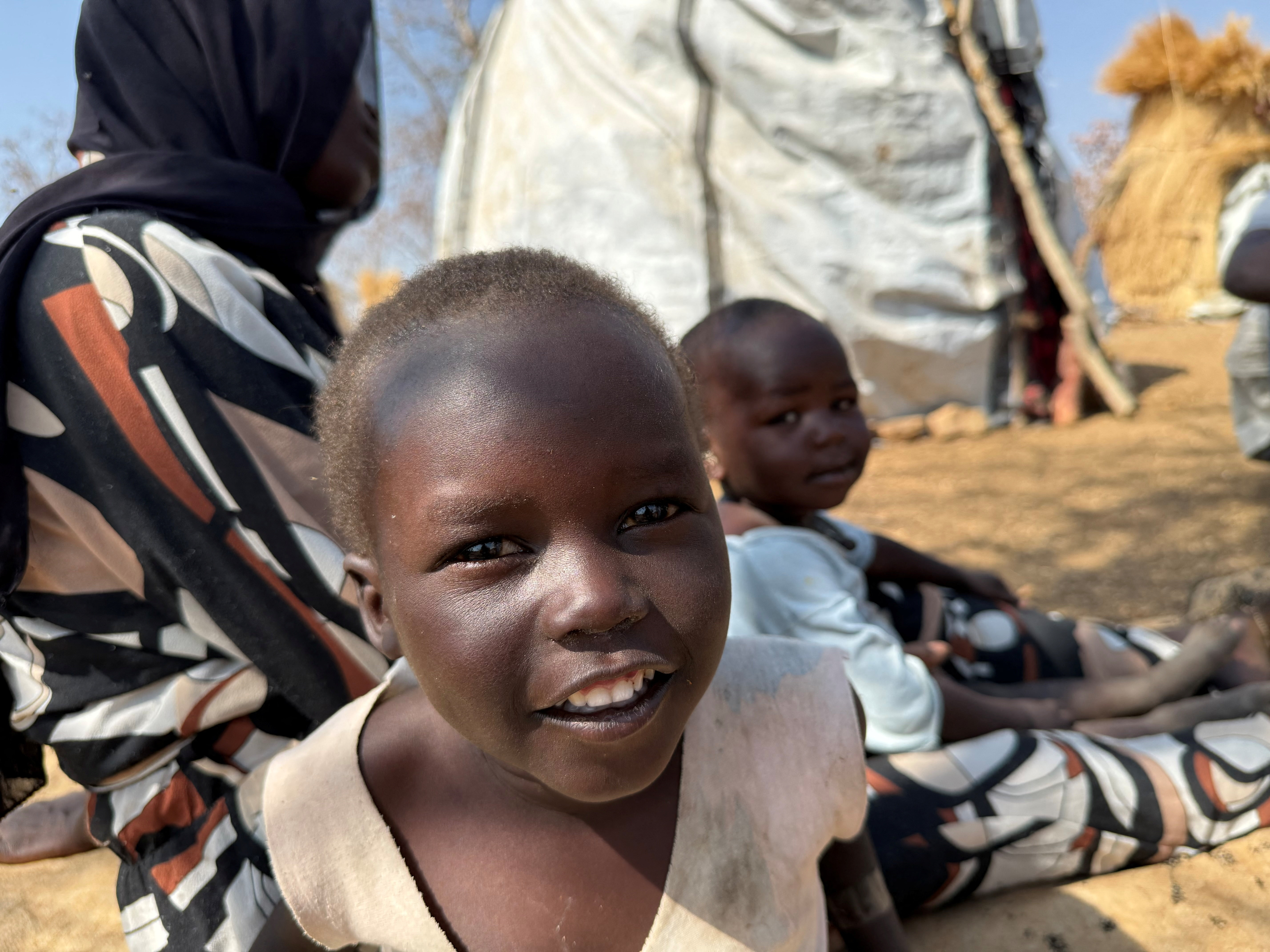A boy reacts as he sits with his family displaced from Kadugli at Embal Camp in Engpung County