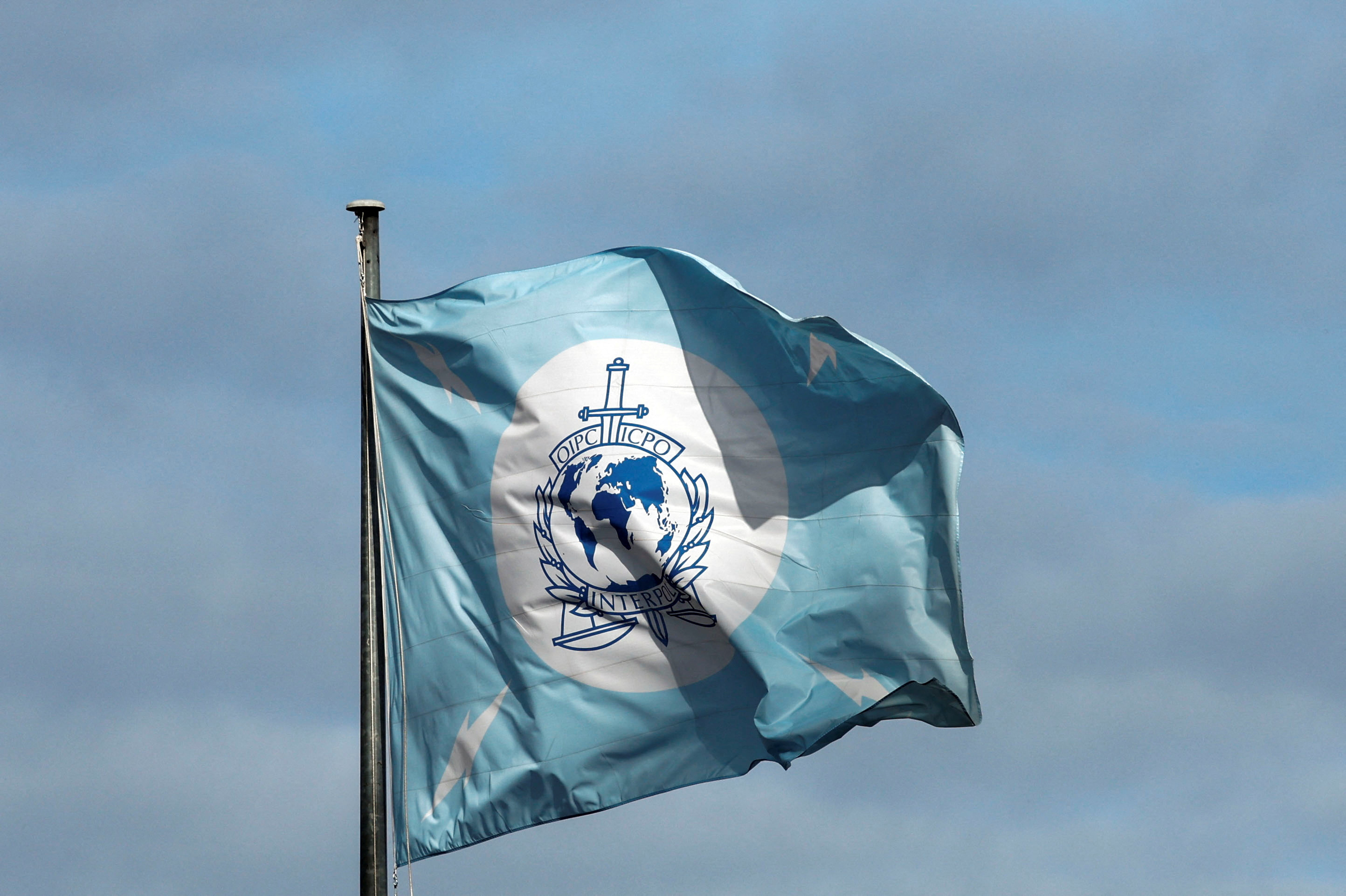 A flag with the logo of the International Criminal Police Organization (INTERPOL) is seen at the headquarters in Lyon