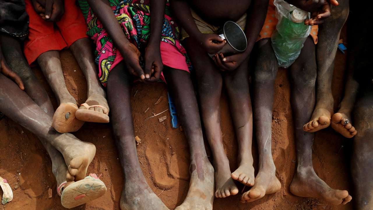 FILE PHOTO: Internally displaced orphans from Kadugli gather to eat boiled leaves at an IDP camp in South Kordofan, Sudan